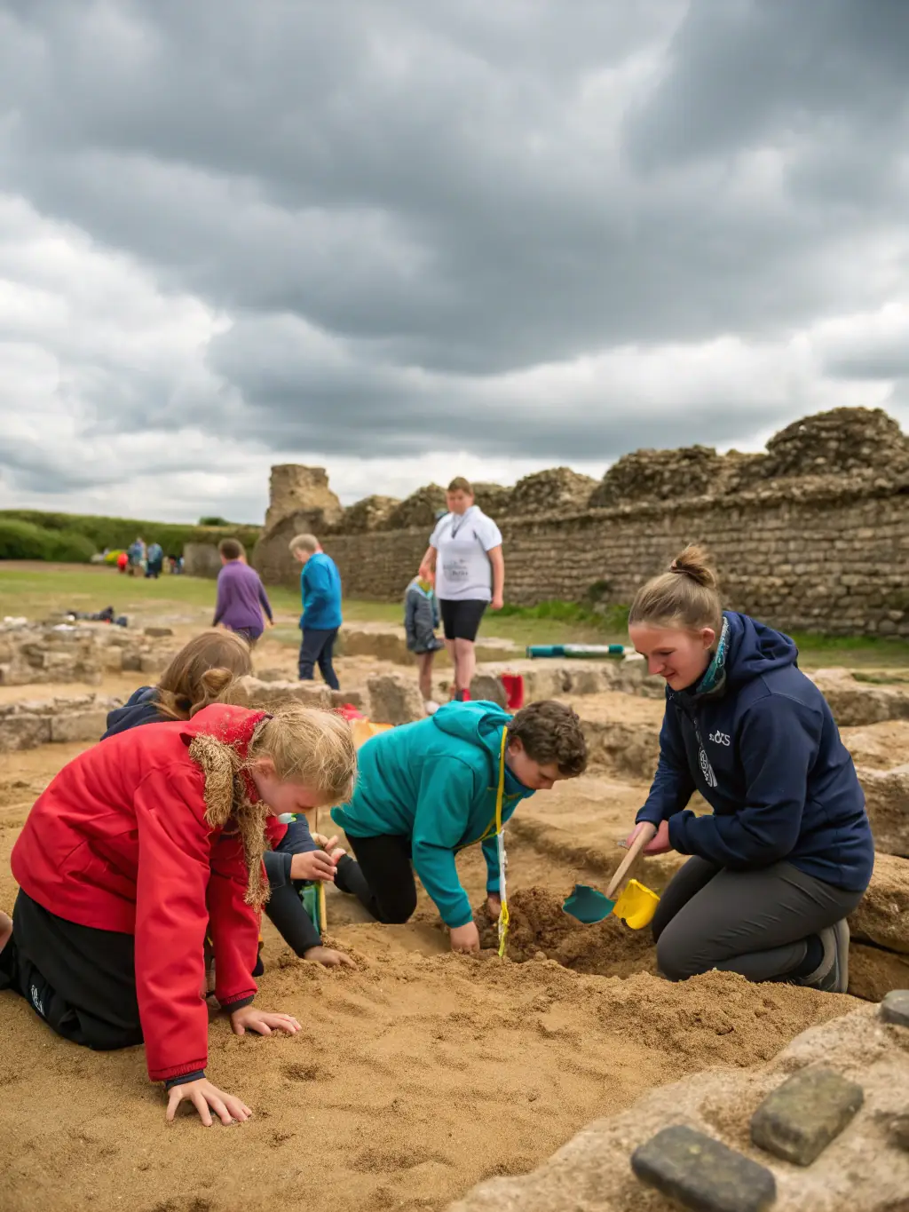 An image of children and adults participating in a hands-on archaeology workshop with artifacts and excavation tools, representing the Educational Outreach and Workshops program.