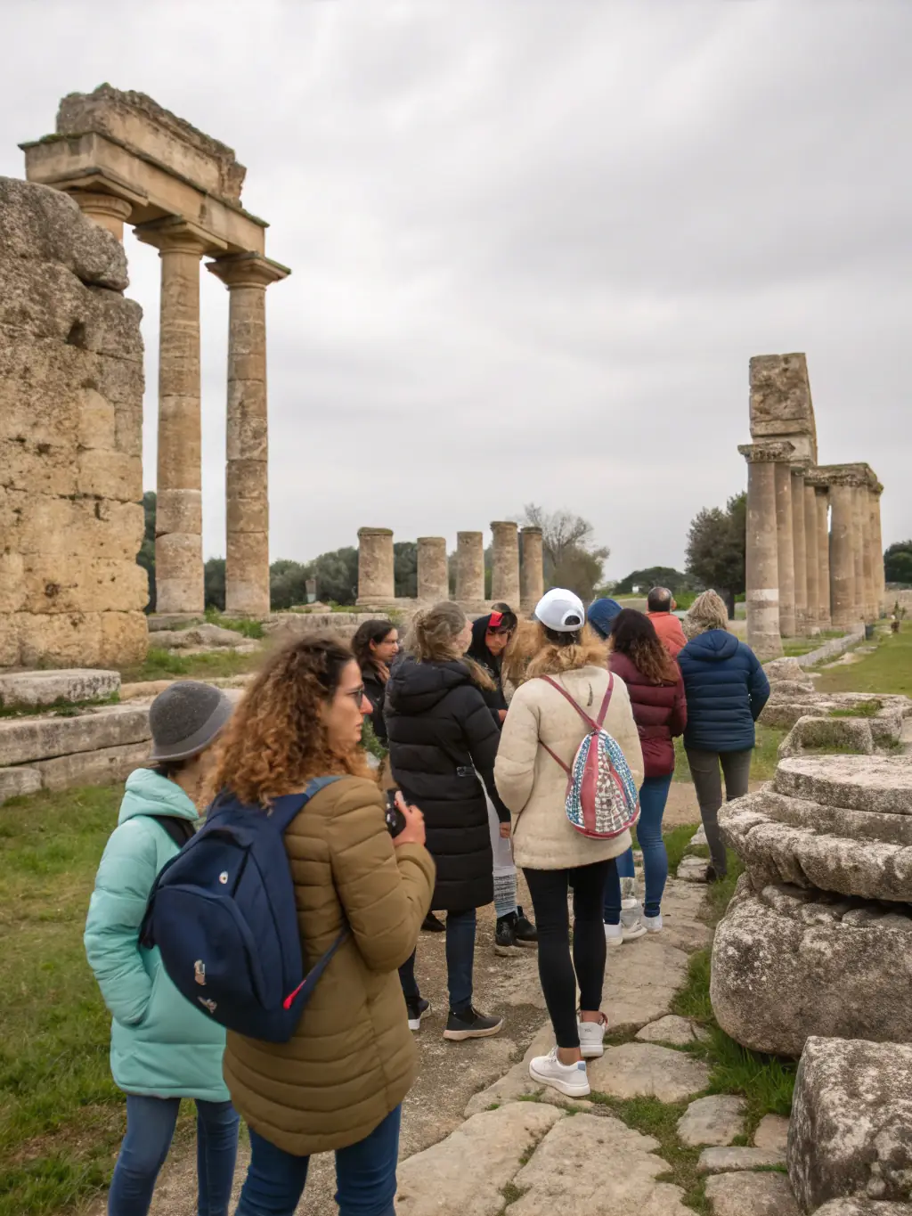 A scenic view of tourists exploring ancient ruins with a knowledgeable guide explaining the site's history, highlighting the Cultural and Heritage Tours offered by HISTOIRE ET ARCHEOLOGIE PAYS D'AUBAZINE.